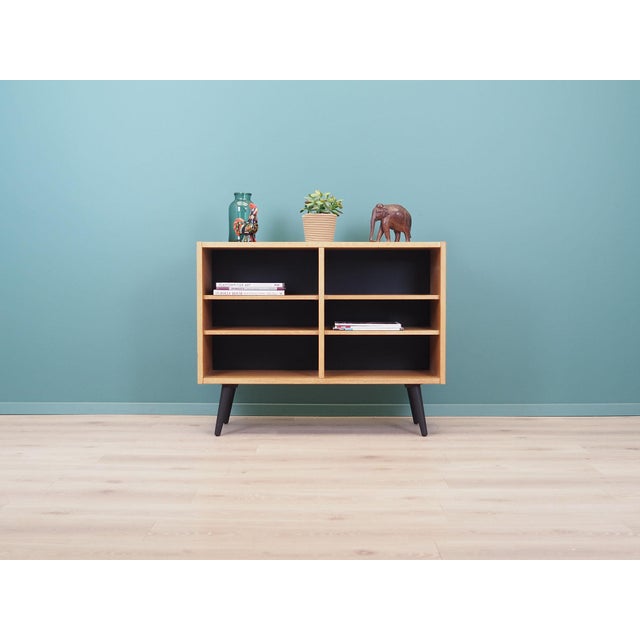 The bookcase was made in the 1970s, Danish production. The structure is covered with ash veneer. Legs made of solid wood,...