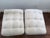 Pair of upholstered X leg benches. Upholstered in warm grey fabric. Tufted cushions are attached. Heavy and solid, in...