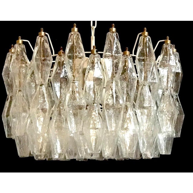 The chandelier consists of 99 hand blown clear "poliedri" made of murano glass. White painted structure. There are 5 e 27...