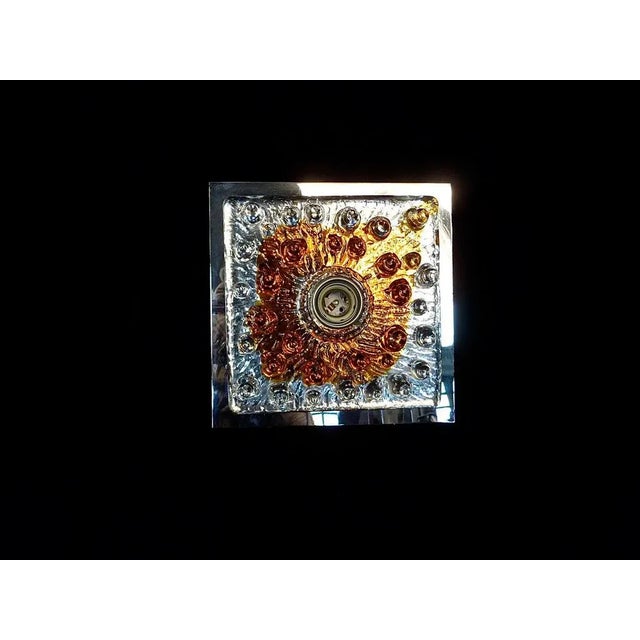 This wall lamp or sconce was made by Mazzega in Italy in the 1960s. It features sculptural colored glass mounted on a...
