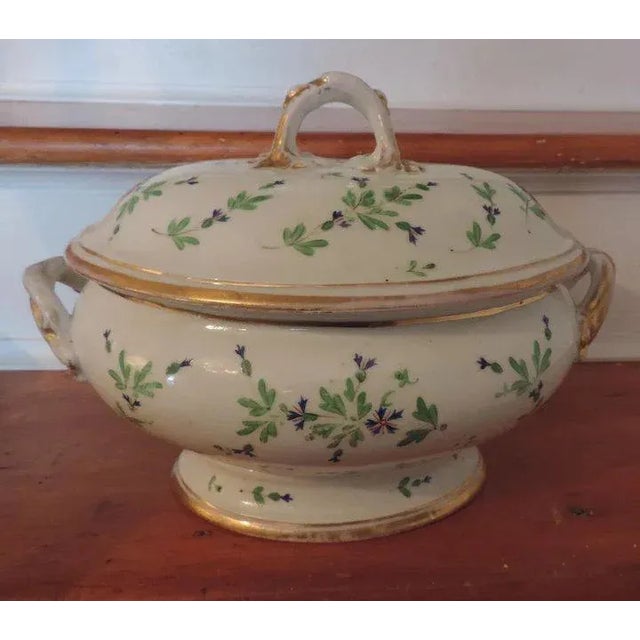 18th c. hard-paste porcelain lidded soup tureen, decorated with cornflowers enhanced by gilding. Measures 13" over loop...