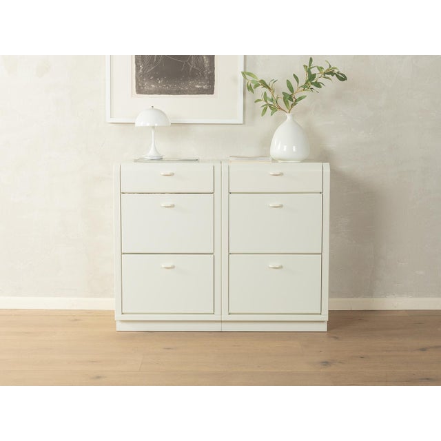 Postmodern chests of drawers from the 1980s from Hülsta. The frame is made of white lacquered particleboard and features...