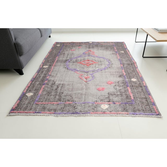 This is a vintage Turkish Oushak rug from the Mid 20th Century. The piece was hand-knotted.