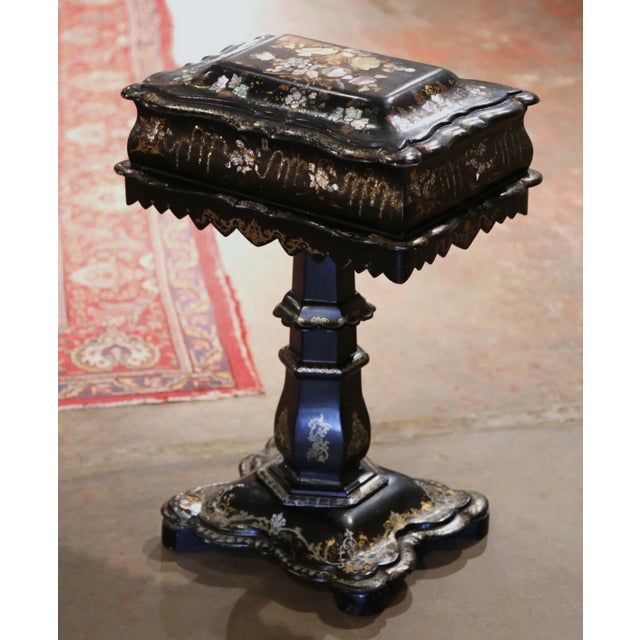 Richly decorated with shimmering mother-of-pearl inlay and delicate gilt ornamentation, this antique Victorian sewing...