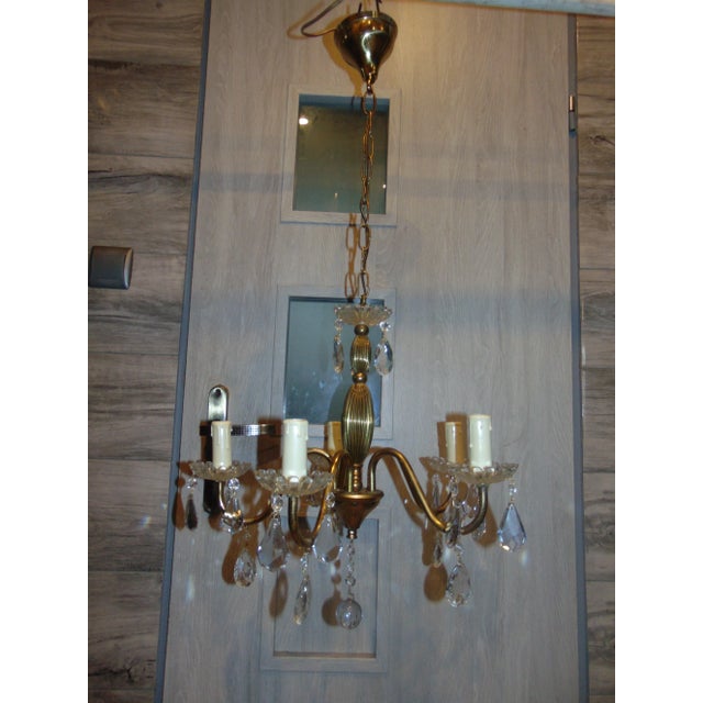 This brass chandelier with glass crystals was produced in the 1950s and requires E14 bulbs. European Plug (up to 250V).The...