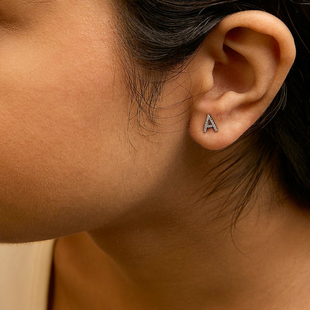 Expertly crafted to symbolize individuality and grace, this exquisite "A" initial stud earring is fashioned from radiant...