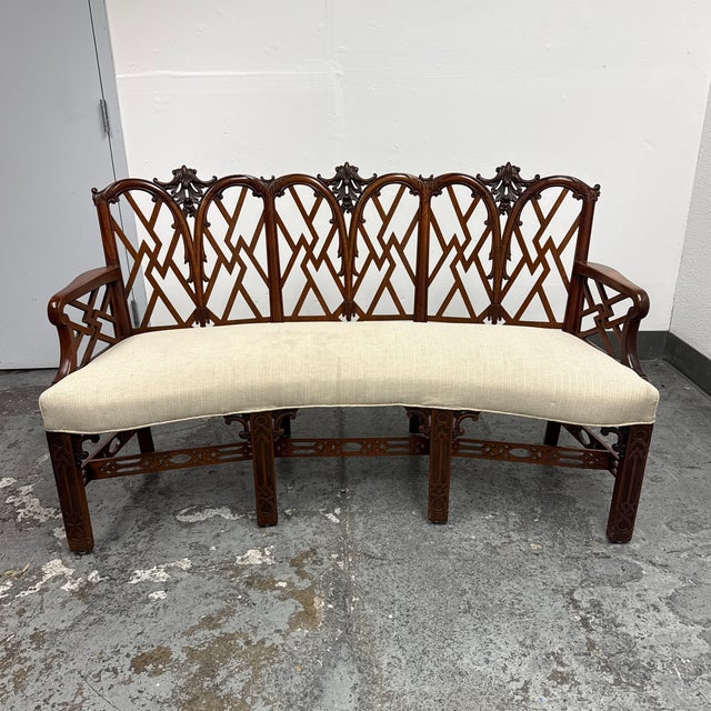 Design Plus Gallery presents a Chippendale Style Settee. This vintage settee has a carved wood frame with an open lattice...