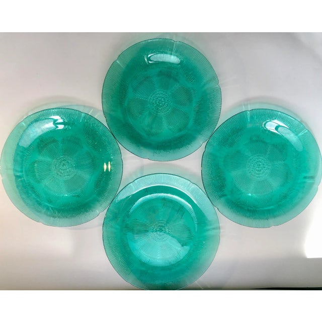 A beautiful set of clear textured green dinner plates with a central abstract floral medallion and a line work border.
