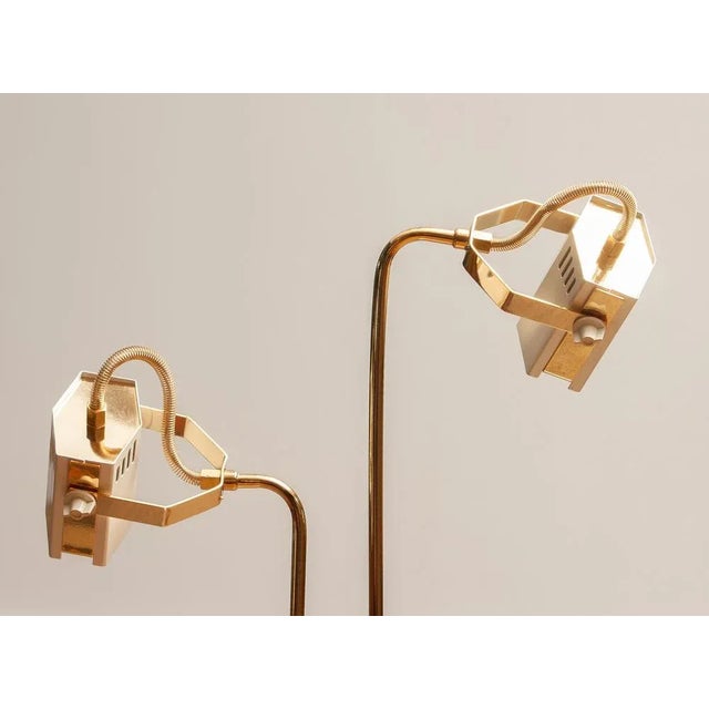 An Italian floor lamp from the 1980s, finished in white pearlescent lacquer with brass details. Designed with two...