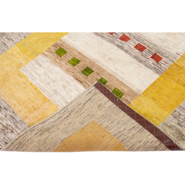 Beautiful modern Gabbeh hand-knotted wool rug with a brown and yellow field. This Persian rug has green, red, and beige...