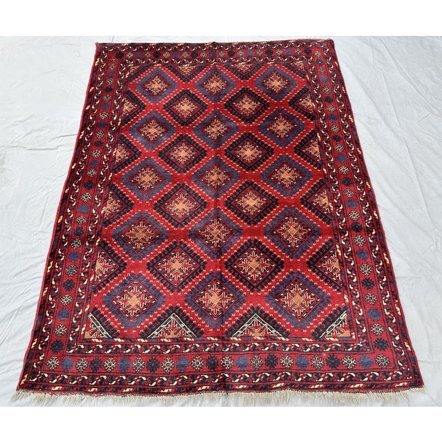 Bring rich texture and sophisticated tribal craftsmanship to your living space with this striking hand-knotted wool area...