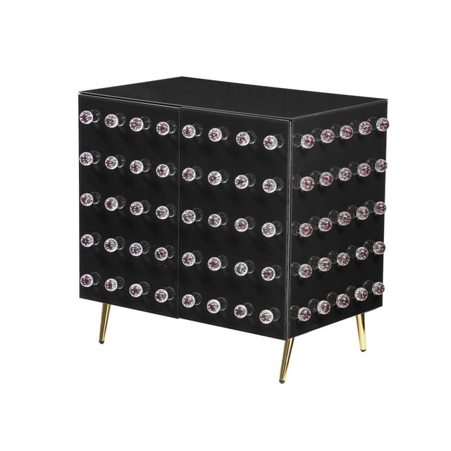 This cabinet features 90 refined glass spheres decorating a rich black glass surface. Opulent brass feet complete the...