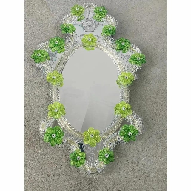 Impressive wall mirror with Murano glass style with transparent elements full of gold leaf and green flowers. Oval mirror...
