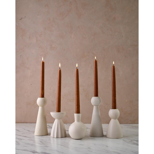 The Sculptural Quintet of Ceramic Candle Holders by Lostine is a handcrafted collection of five ceramic taper candle...