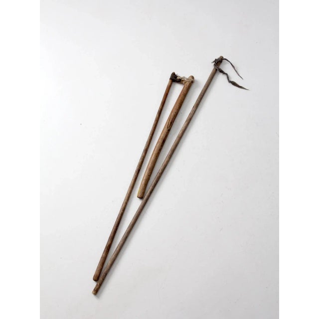 These are antique primitive farm tools. The rustic agriculture flails are hand-held grain threshers. Rustic wood poles...