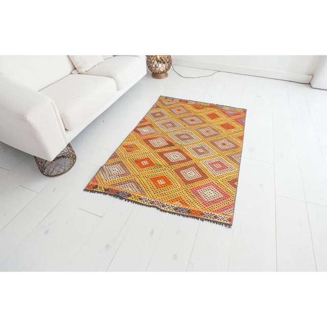 This is a vintage Turkish Oushak rug from the Mid 20th Century. The piece was hand-knotted.