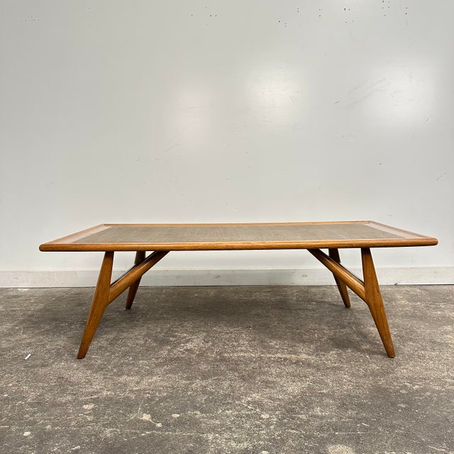 1950s oak coffee table designed by Jack Van Der Molen for Jamestown Lounge Company. This piece features a textured vinyl...