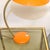 An orange space age desk lamp from the 1970s. The arm can be adjusted and also the shade itself can be repositioned....