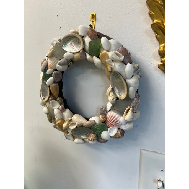 A very pretty handmade sea glass and shell on woven wicker, year round or holiday wall hanging or front door decor.