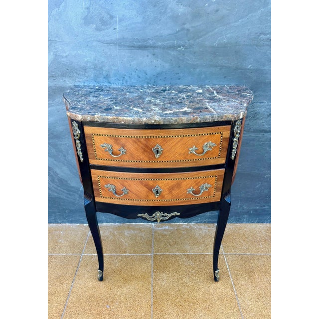 Elegant Louis XV style petite commode with marble top, dating to the mid-20th century. The chest features a serpentine...