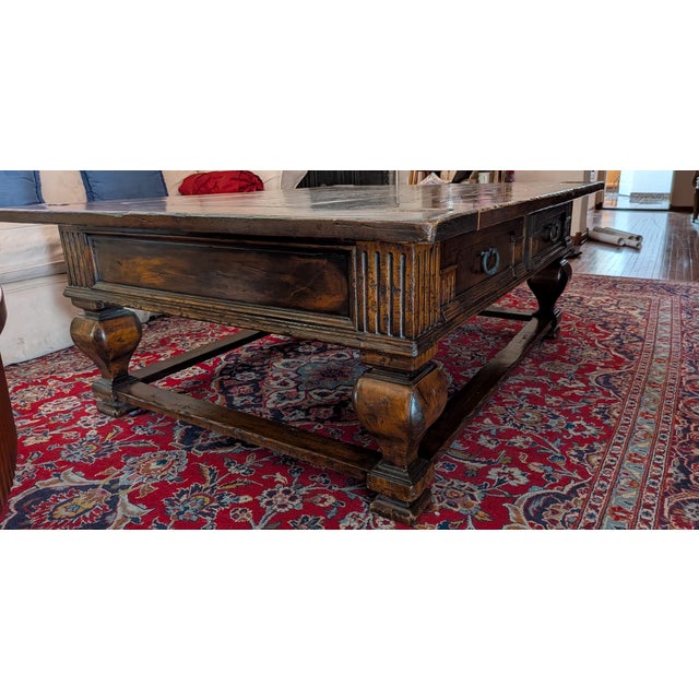 A classic Country French French rectangular coffee table features an intricate carved wooden apron, curvaceous legs and...