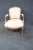Early 1900’s Louis XV style open arm chair . Frame is made of solid cherry , floral carved accents , cream patterned fabric