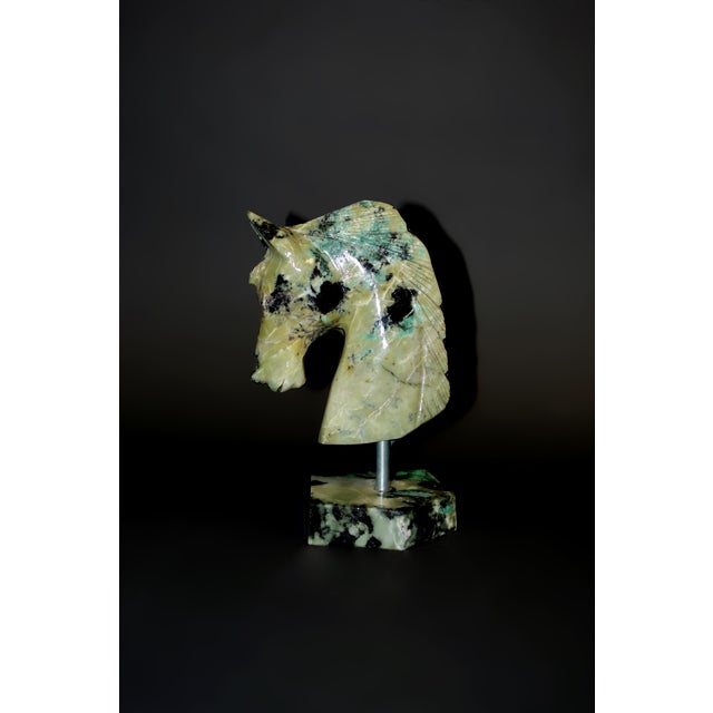 A captivating horse bust hand-carved from genuine Brazilian emerald, showcasing the rare transformation of one of the...