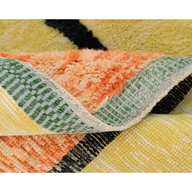 Exquisite hand-knotted wool rug, captivating with its kaleidoscope of vibrant colors and dynamic patterns. Infusing both...