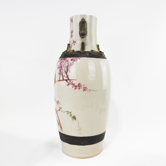 A stunning antique Chinese porcelain vase featuring a delicate hand-painted scene of a red and black bird perched on a...