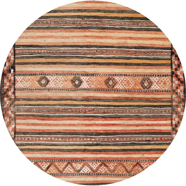 A beautiful hand-woven vintage kilim rug with a tan field, and multi-color accents in an all-over stripe design. This rug...