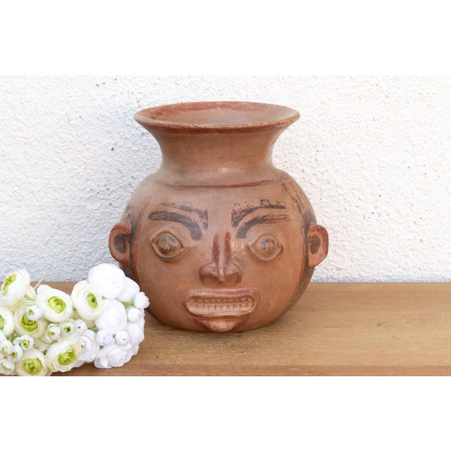This terracota vase is a captivating anthropomorphic vessel that pays homage to the sophisticated ceramic traditions of...
