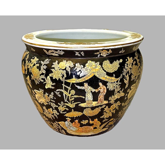 Hand-painted Asian porcelain fishbowl planter featuring traditional figural scenes and architectural motifs. The exterior...