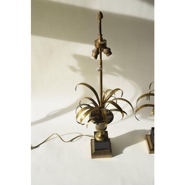 This pair of Maison Charles 'Vase Roseaux' brass palm lamps from the 1950s reflects timeless French craftsmanship. The...