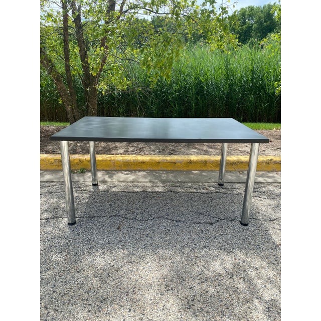 Beautiful sleek and modern 1970s Formica and chrome rectangular dining table. Featuring legs that are adjustable up to an...