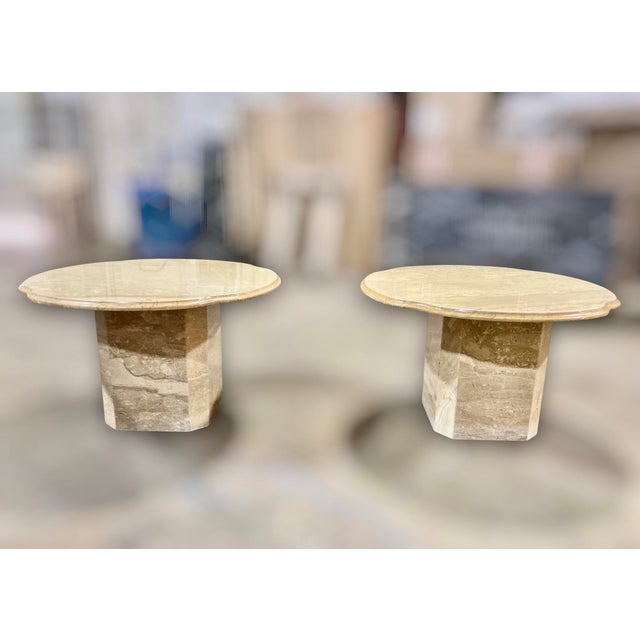 This elegant pair of 1970s Italian travertine end tables features finely veined tops with distinctive scalloped edges, set...