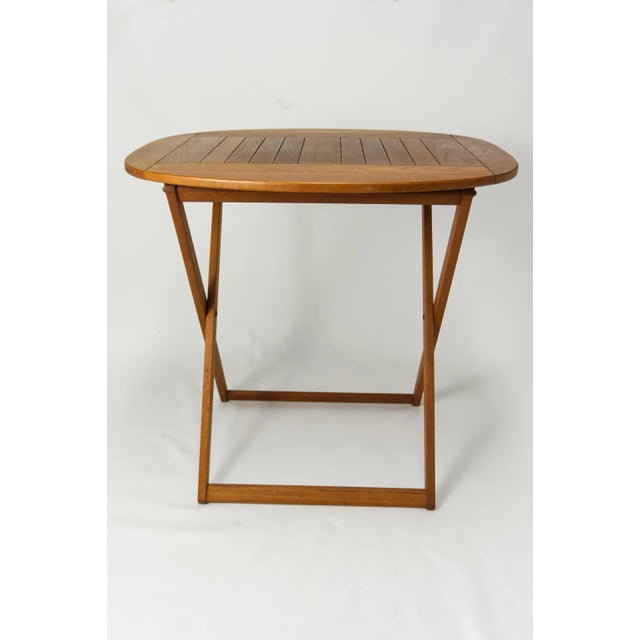 Mid-Century Danish Modern folding teak accent table by Drylund. Oval Top on folding "X" frame base. The perfect accessory...