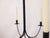 This hand made iron chandelier for candles has old, distressed wooden pendants.