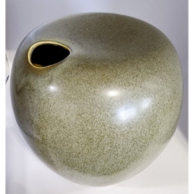 This is a unique vase with a contemporary look in an olive-green, speckled color. An off-set opening to the vase and a dip...