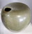 This is a unique vase with a contemporary look in an olive-green, speckled color. An off-set opening to the vase and a dip...