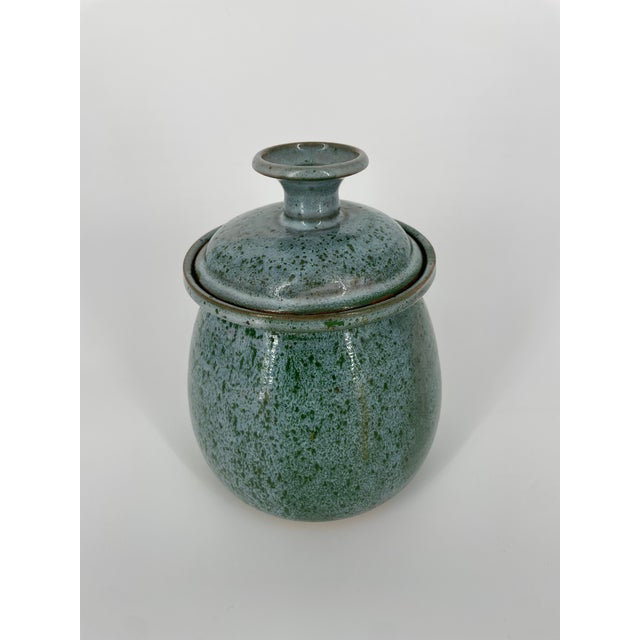 Beautiful glossy dripped blue glazed art pottery lidded jar with green speckles. Bottom is signed by the artist....
