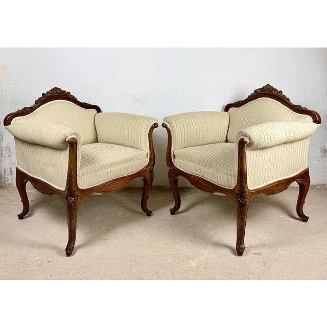 Elegant pair of French Louis XV style armchairs dating from the 1960s, featuring gracefully carved wooden frames, shaped...