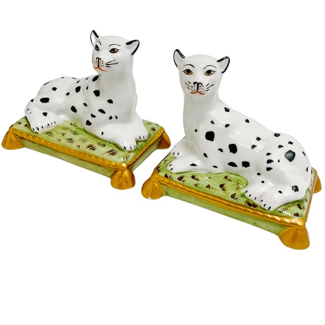 Pair of contemporary Staffordshire style porcelain reclining black spotted white snow leopards. They look so regal as they...
