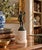 A Grand Tour–style classical figure in brass, mounted on a cylindrical marble base. The slightly more relaxed posture and...