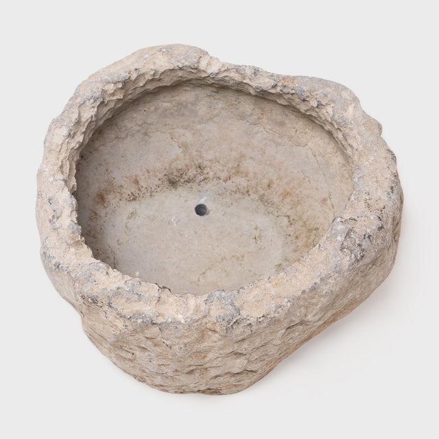 This stone basin was carved by hand over two centuries ago, sculpted from solid limestone with and irregular texture and...