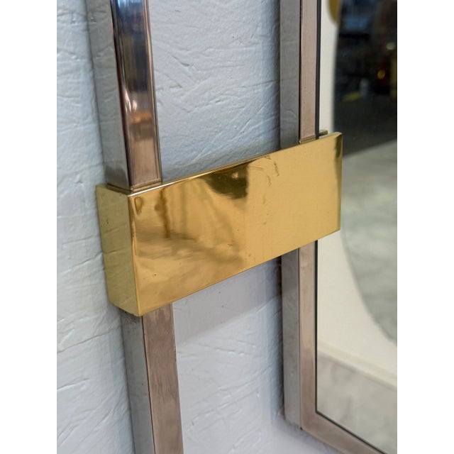 A bold Italian octagonal wall mirror framed in polished chrome with striking brass corner mounts. The geometric design...