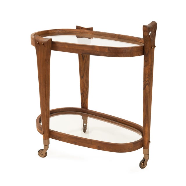 Crafted from rich wood with a warm finish, this sleek oval design features two tinted glass shelves that reflect elegance...