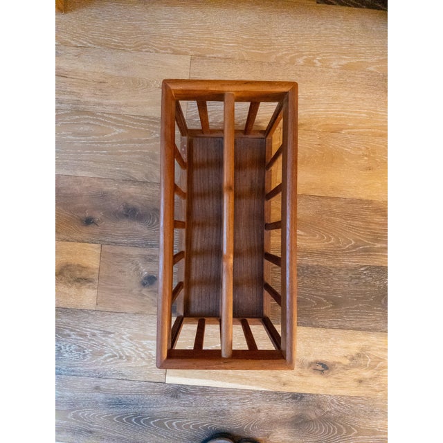 Beautiful genuine teak magazine rack in a Danish mid-century style. Handle in the middle row with slatted sides. This is...