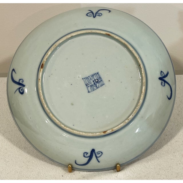 This is a vintage hand painted Chinese plate with blue underglaze decorations that include scenes of homes, boats,...