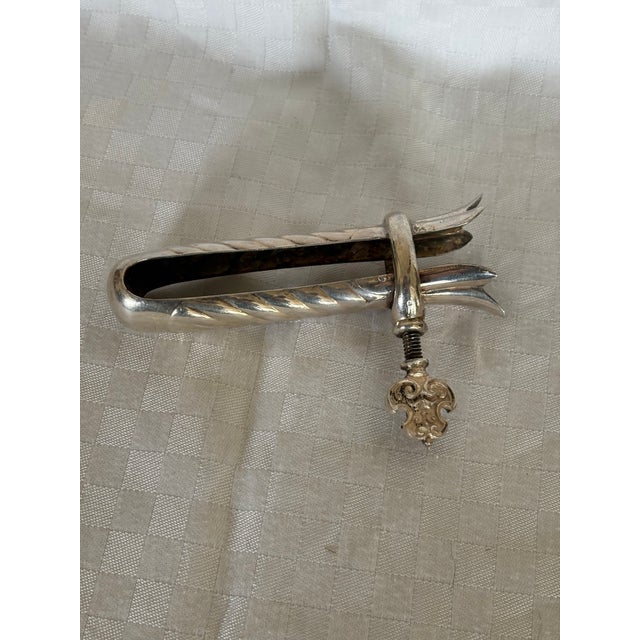 A rare silverplate roast assist. This piece was designed to hold the bone of a roast while it is carved. It has a screw...