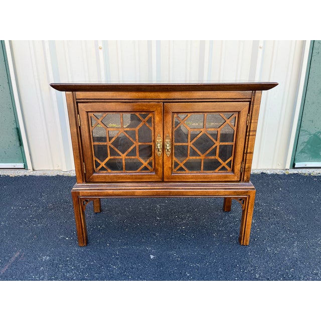 Mid-century walnut nightstand or side table with heavy Asian influence and chinoiserie stylized elements. Imitating a...